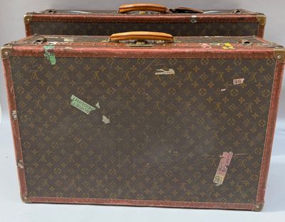 une paire de valises Louis Vuitton ornées d'autocollants