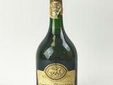 une vieille bouteille de champagne posée sur une surface blanche