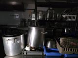Plusieurs casseroles et poêles sont posées sur une table dans une cuisine.