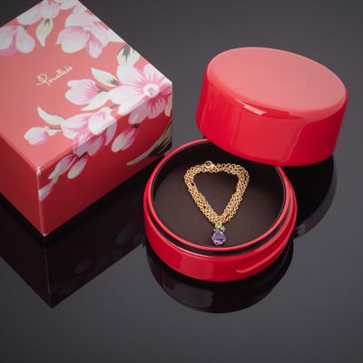 une boîte rouge avec une chaîne en or et un pendentif en forme de cœur à l'intérieur