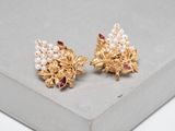 a close up of a pair of gold and pearl earrings