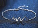 un bracelet en argent sur lequel est gravée la lettre « w »