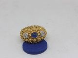 a close up of a gold ring with a blue stone