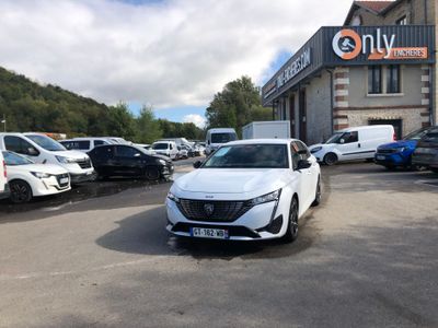 une voiture blanche garée sur un parking devant un immeuble