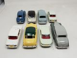 several toy cars are lined up in a row on a white surface