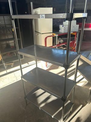 une étagère métallique avec des tablettes, placée au milieu d'une pièce