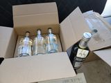 six bouteilles d'alcool dans un carton posé par terre