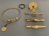 several gold jewelry items are displayed on a gray surface
