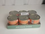 six bobines de fil orange dans une boîte posée sur une surface blanche