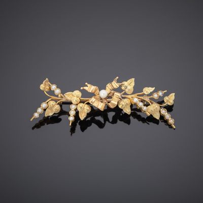 a close up of a gold and pearl flower broochle