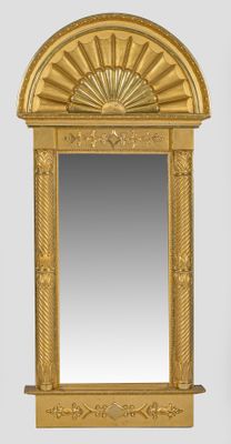 une image représentant un miroir doré surmonté d'un motif en rayons de soleil