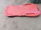 un skateboard en plastique rouge posé par terre