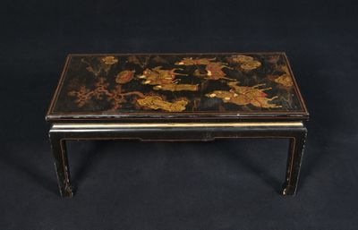 a black and gold coffee table with flowers on it