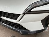 the front bumper of a white car with a black grille
