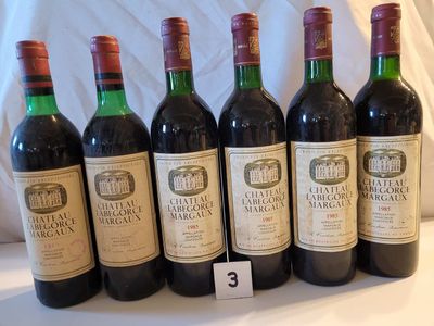 six bouteilles de vin rouge sont alignées sur une table