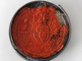 a tin with a red substance in it on a white surface