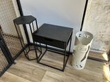 a black table and two stools in a room