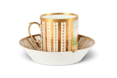 une tasse et une soucoupe posées sur une assiette à bord doré