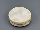 a white container with a mesh lid sitting on a table