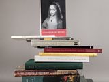 des livres empilés les uns sur les autres, avec la photo d'une femme posée dessus