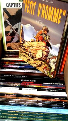 many books stacked on top of each other on a shelf
