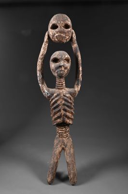 une image représentant une statue d'un squelette tenant deux crânes