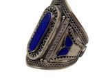 a close up of a ring with a blue stone in it