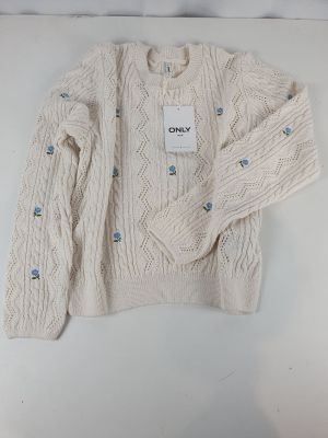 the sweater is white and has blue buttons on it