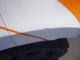 a close up of a white and orange car with orange stripes