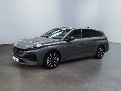 Une voiture grise est garée dans une pièce aux murs blancs.