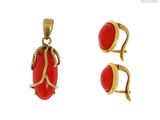un gros plan sur une paire de boucles d'oreilles et un pendentif sur fond blanc