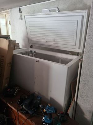 a white chest freezer sitting on top of a wooden table