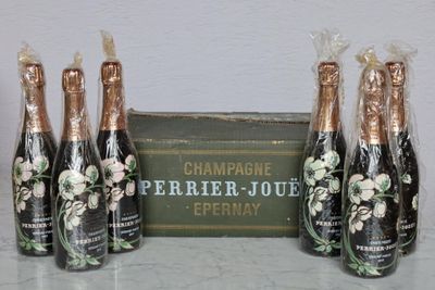 four bottles of champagne sitting on top of a table next to a box