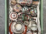 une boîte verte posée par terre et remplie d'objets divers