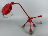 an image of a red table lamp with wheels on a white background