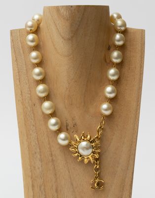 a close up of a necklace on a mannequin with pearls
