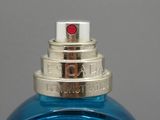 une image représentant un flacon de parfum bleu posé sur une table