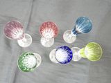 five different colored wine glasses sitting on a table