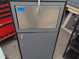 a metal cabinet with a red knob on top of it
