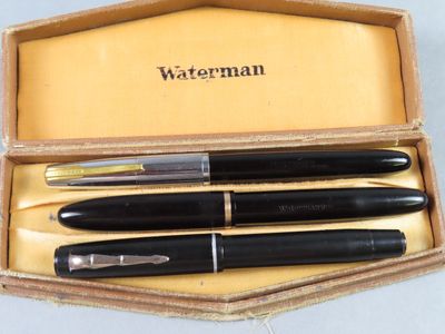 Deux stylos à plume se trouvent dans une boîte dont le couvercle est jaune.
