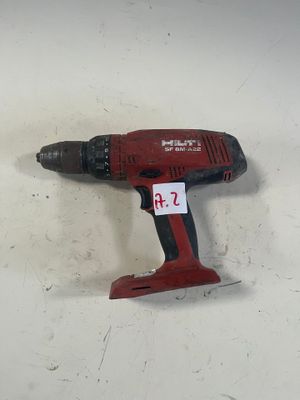 une perceuse rouge posée sur une table