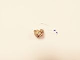 a small bead hanging from a string on a white surface