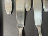 five forks and a knife on a black table