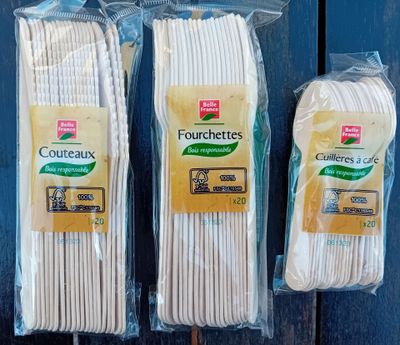 three bags of white cotton are sitting on a wooden table