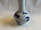 un petit vase bleu et blanc posé sur une table