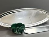 un plateau en argent avec un couteau et un miroir posé sur la table