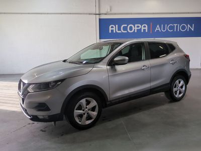un SUV argenté garé dans un garage au-dessus duquel est accrochée une pancarte
