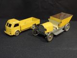 two toy trucks sitting next to each other on a black surface