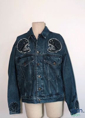 denim jacket with patches on the front and back of a mannequin torso