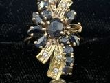 an image of a gold ring with black and white stones in it